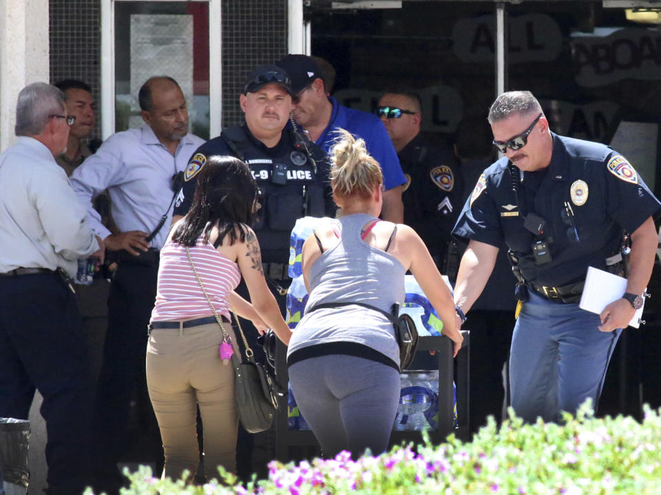 People walk into an elementary school to look for loved ones near the site of a mass shooting at a shopping centre in El Paso, Texas, on Saturday.