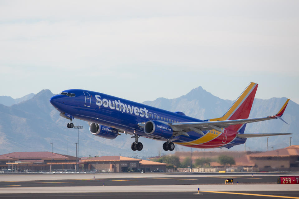 A Southwest Airlines plane taking off, with mountains in the background