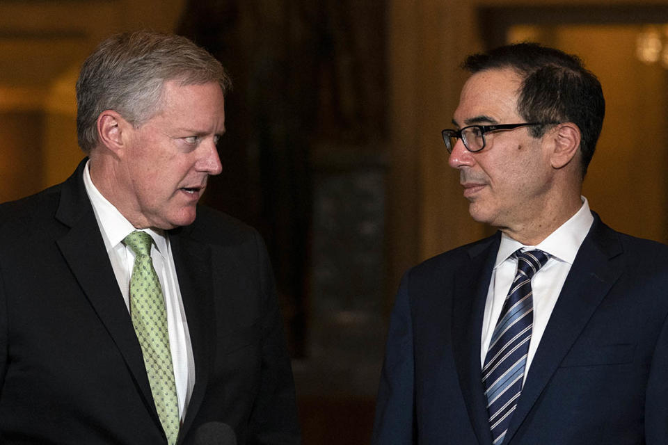 Treasury Secretary Steven Mnuchin and White House chief of staff Mark Meadows look to each other as they speak to reporters on Capitol Hill in Washington, Thursday, Aug. 6, 2020. (AP Photo/Carolyn Kaster)