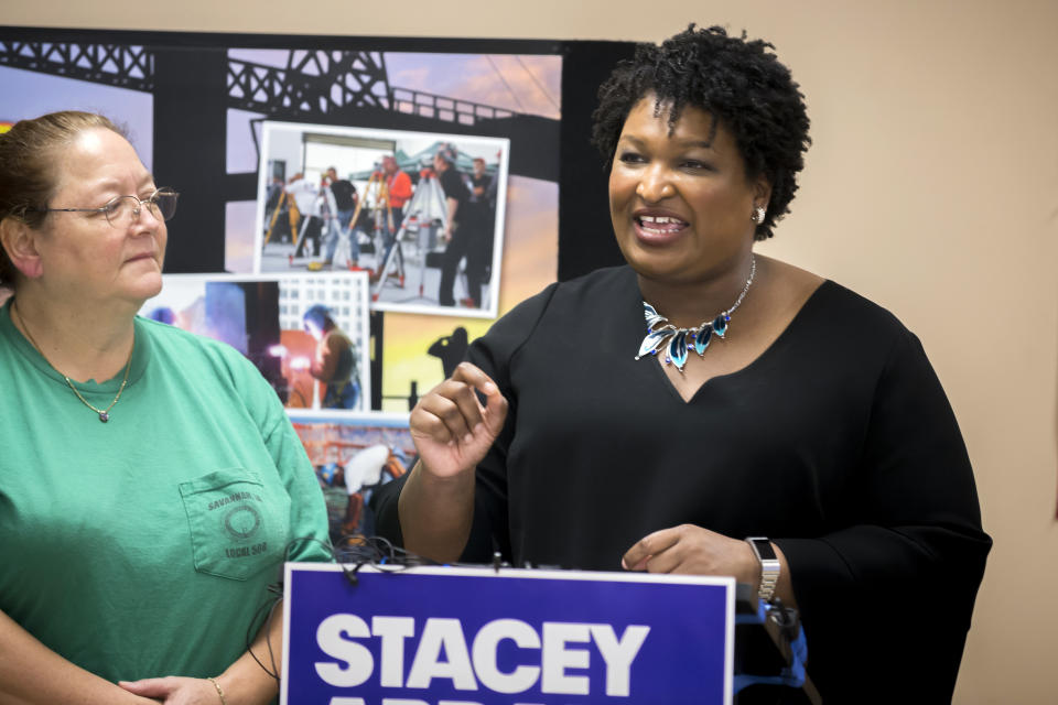 FILE - In this July 26, 2018 file photo, Georgia Democratic gubernatorial candidate Stacey Abrams, center, speaks with the media during a campaign stop at the Ironworkers Local 709 apprenticeship shop to announce her "Jobs for Georgia Plan," in Pooler, Ga. The history-making gubernatorial runs by Abrams of Georgia, Andrew Gillum of Florida and Ben Jealous of Maryland are turning them into stars nationwide and at the Congressional Black Caucus annual legislative conference. If elected, Abrams, Jealous and Gillum, would give America its largest number of black governors ever. (AP Photo/Stephen B. Morton, File)