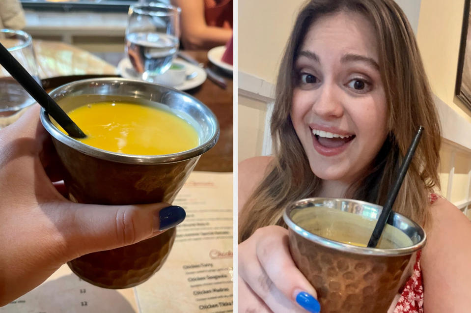 author smiling and holding a mango lassi