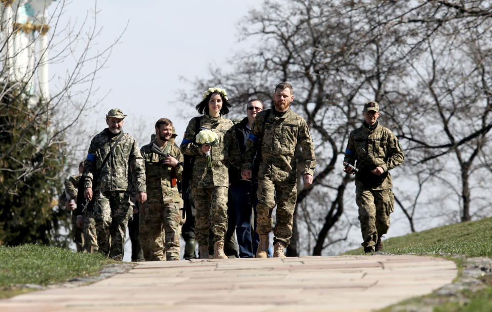 Members of the Ukrainian Territorial Defence Forces Anastasiia (24) and Viacheslav (43) walk to attend their wedding ceremony, amid Russia's invasion of Ukraine, in Kyiv, Ukraine, April 7, 2022. REUTERS/Mykola Tymchenko