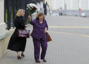 Belarusian Svetlana Alexievich, the 2015 Nobel literature laureate waves a bunch of flowers her supporters and journalists on her way to the Belarusian Investigative Committee in Minsk, Belarus, Wednesday, Aug. 26, 2020. Svetlana Alexievich has been summoned for questioning over the protests in an apparent attempt by authorities to intimidate her. (AP Photo/Sergei Grits)
