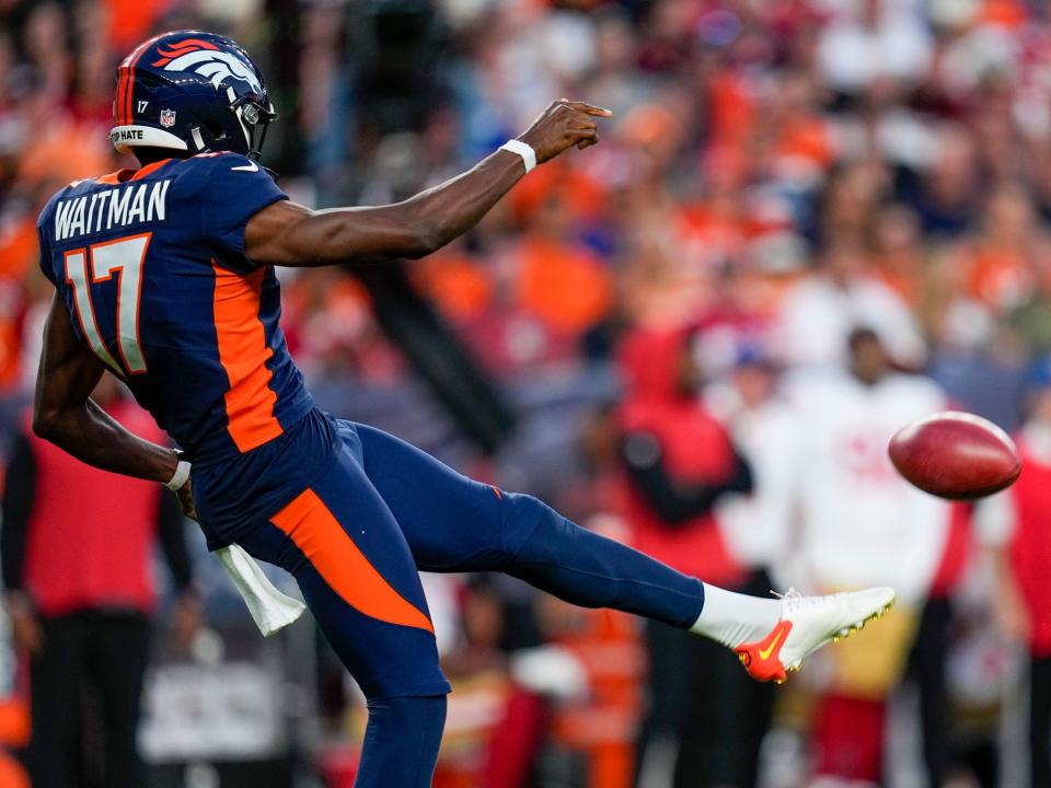 Corliss Waitman punts against the San Francisco 49ers.