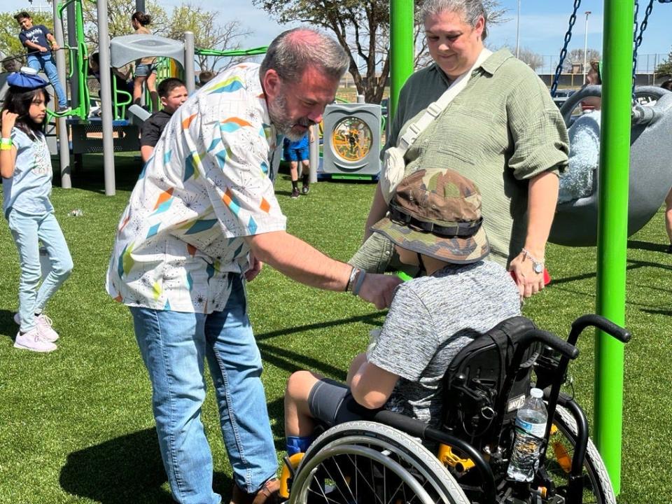 Abilene city council member Kyle McAlister engages with child at the ribbon cutting ceremony for the new ADA-compliant playground at Arthur Sears Park, 2250 Ambler Avenue, on Wednesday, March 13, 2024.