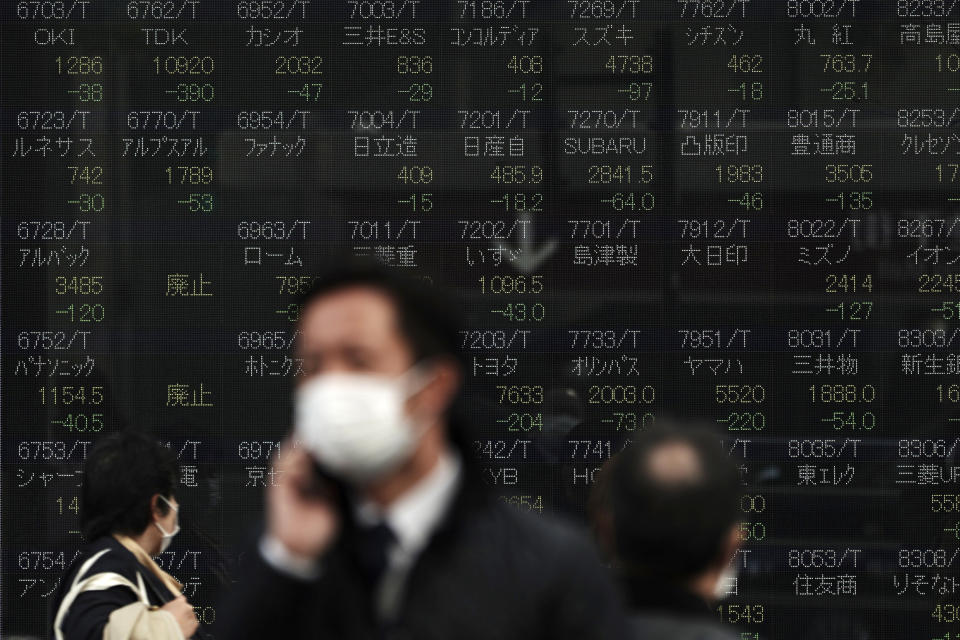 People walk past an electronic stock board showing Japan's Nikkei 225 index at a securities firm in Tokyo Tuesday, Feb. 25, 2020. Shares are mostly lower in Asia on Tuesday after Wall Street suffered its worst session in two years, with the Dow Jones Industrial Average slumping more than 1,000 points on fears that a viral outbreak that began in China will weaken the world economy.(AP Photo/Eugene Hoshiko)