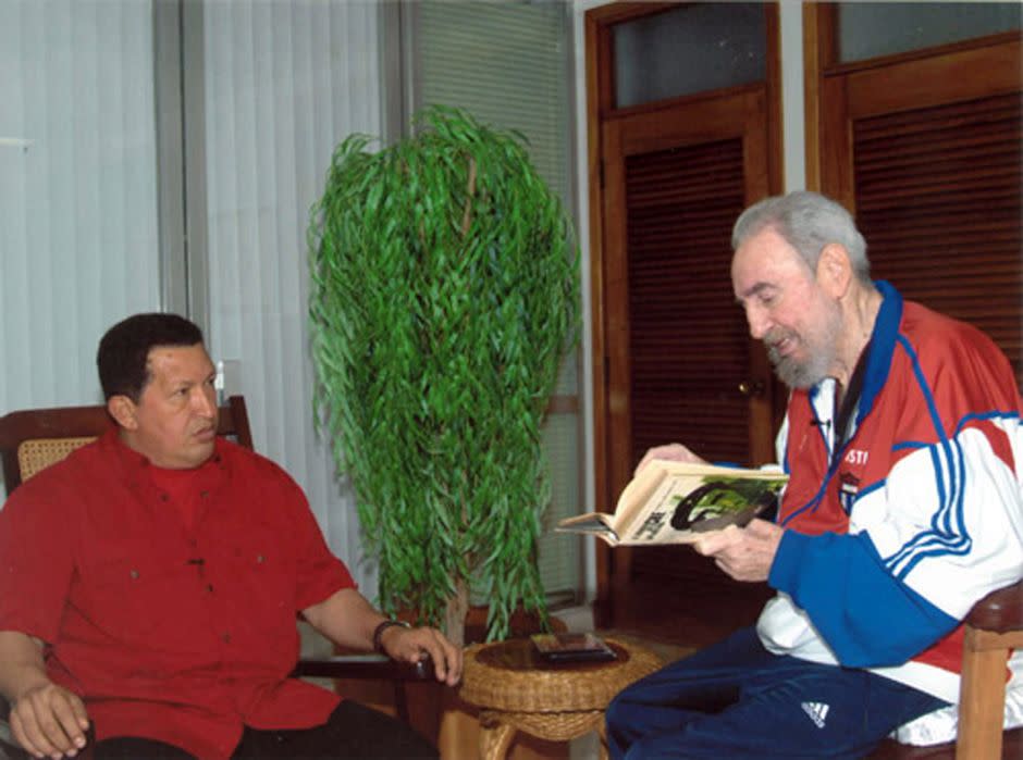 Reads a book to Venezuelan president Hugo Chavez in Havana October 13, 2007. (Reuters/Handout/Juventud Rebelde)