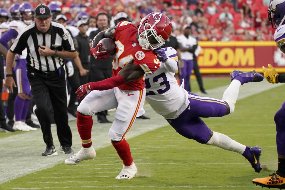 Kansas City Chiefs running back Darwin Thompson (34) runs with the ball as Minnesota Vikings safety Xavier Woods (23) defends during the first half of an NFL football game Friday, Aug. 27, 2021, in Kansas City, Mo. (AP Photo/Charlie Riedel)