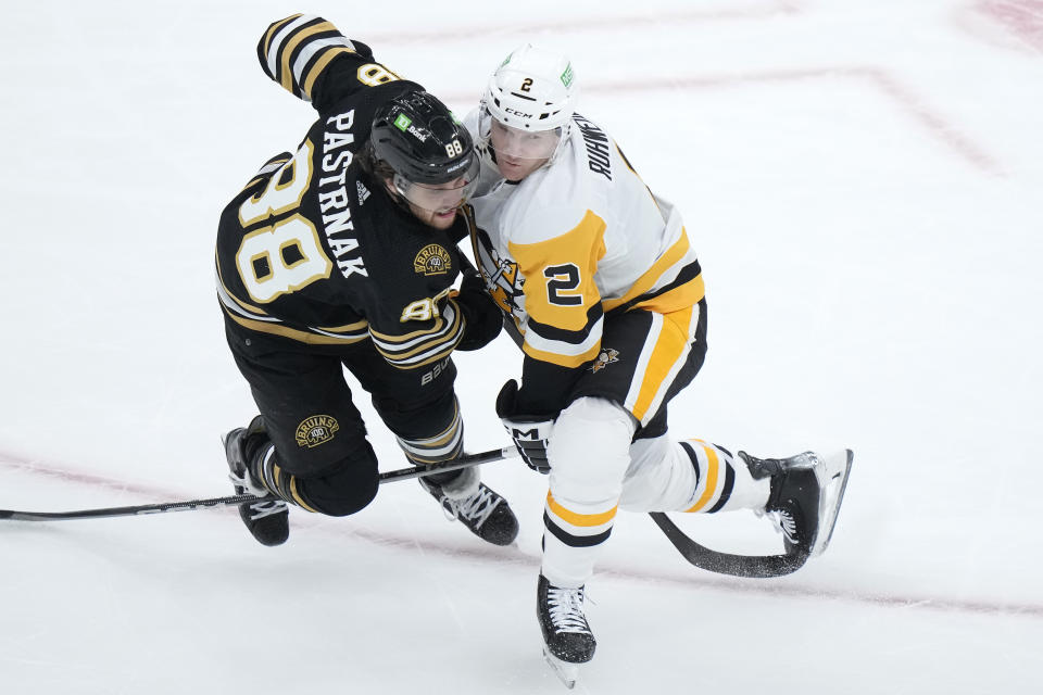 Boston Bruins right wing David Pastrnak (88) and Pittsburgh Penguins defenseman Chad Ruhwedel (2) collide in the first period of an NHL hockey game, Thursday, Jan. 4, 2024, in Boston. (AP Photo/Steven Senne)