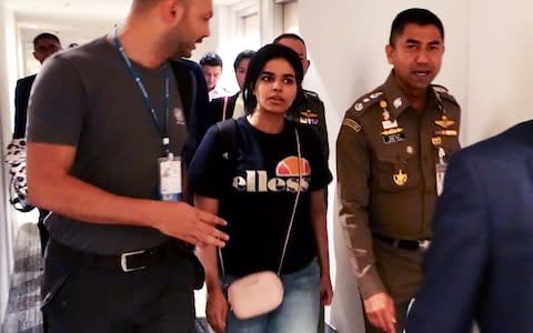 Rahaf al-Qunun with Thai and UNHCR officials in Bangkok airport - Credit: AFP