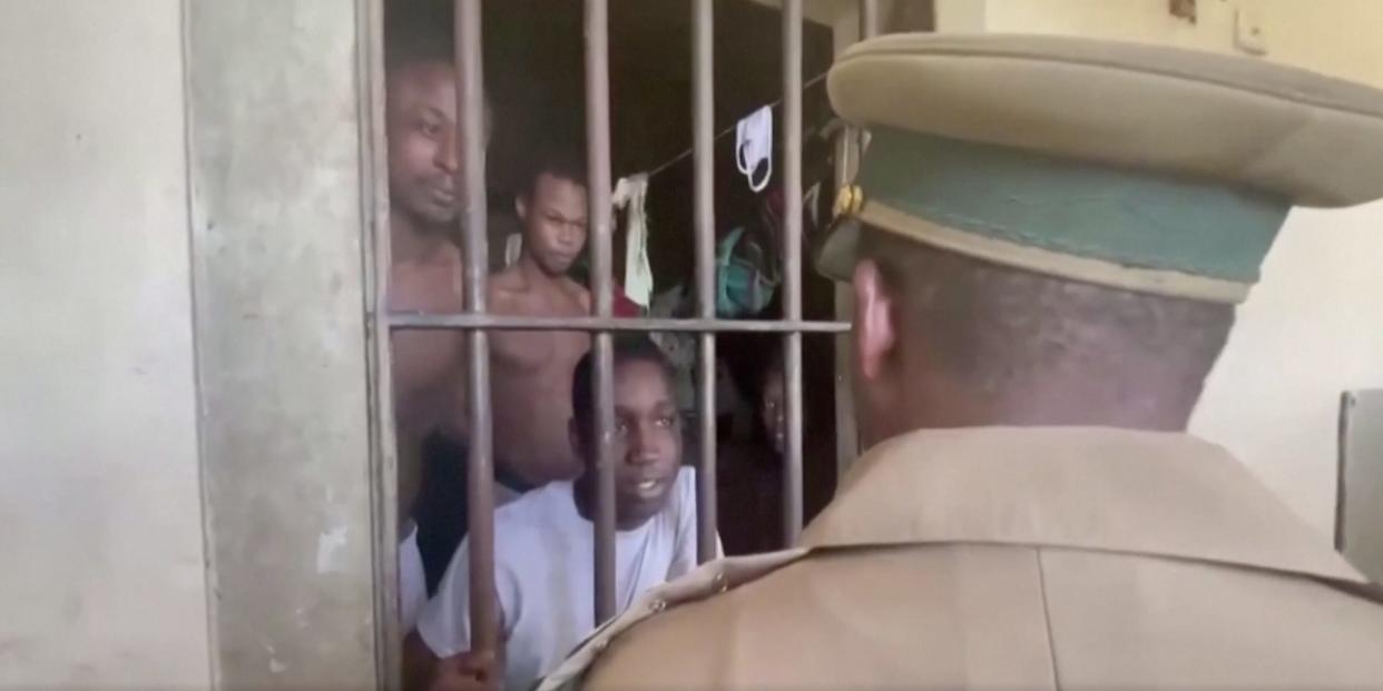 A corrections officer at Fox Hill looks in on a crowded cell of prisoners.