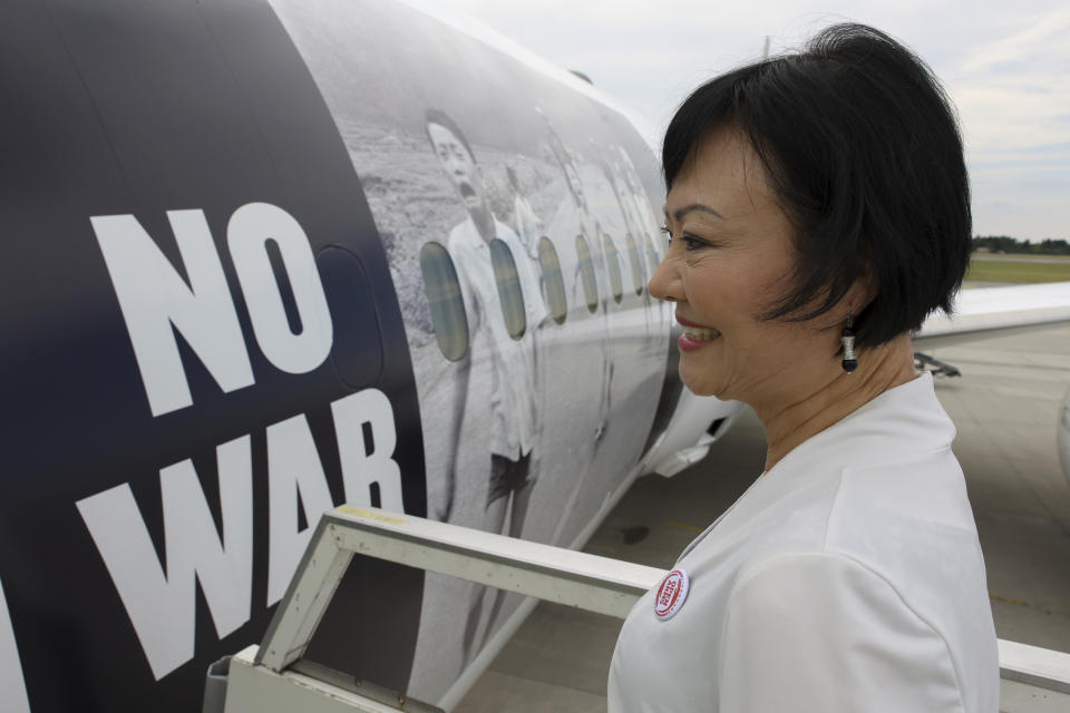 Kim Phuc, the girl in the famous 1972 Vietnam napalm attack photo, boards a plane transporting refugees fleeing the war in Ukraine to Canada, from Frederic Chopin Airport in Warsaw, Poland, Monday, July 4, 2022. Phuc's iconic Associated Press photo in which she runs with her napalm-scalded body exposed, was etched on the private NGO plane that flew the refugees Monday to the city of Regina, the capital of the Canadian province of Saskatchewan. (AP Photo/Michal Dyjuk)