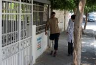 A doctor supervises as Mohannad Aid, 20, who lost his leg when he was hit by a rocket in 2014, walks during a physiotherapy session in Gaza