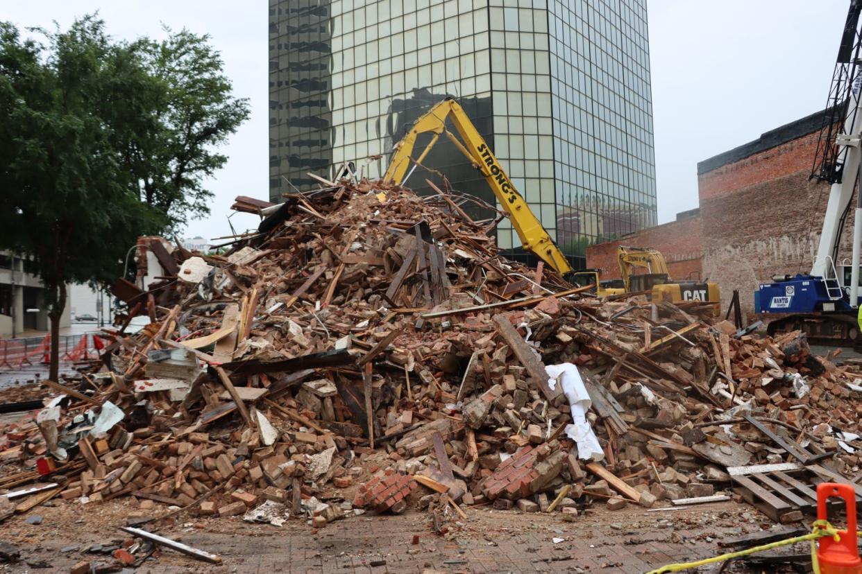 Mark and Mike Mangham of Twin Blends get photos of the demolition of the historic building on 421 Market St. in downtown Shreveport on May 5, 2024. It recently was home to Dripp Donuts and for years before housed Dee's Photo Supply.