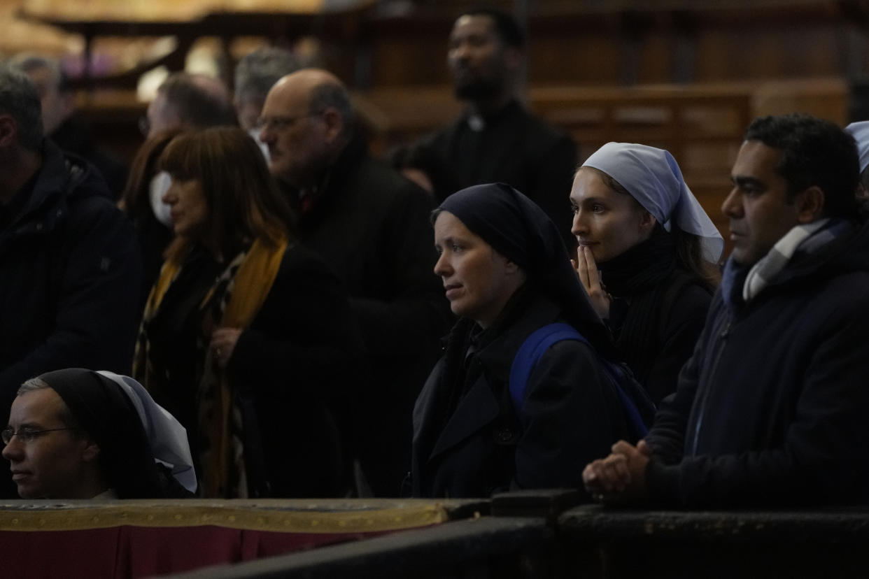 Mouners look at the body of late Pope Emeritus Benedict XVI lied out in state inside St. Peter's Basilica at The Vatican, Wednesday, Jan. 4, 2023. Pope Benedict, the German theologian who will be remembered as the first pope in 600 years to resign, has died, the Vatican announced Saturday, Dec. 31, 2022. He was 95.(AP Photo/Ben Curtis)