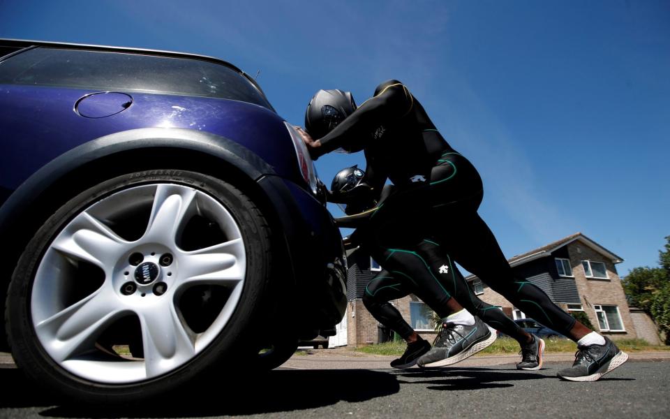 L/Cpl Stephens and Nimroy Turgott push a Mini Cooper around the streets of Peterborough for their training - REUTERS