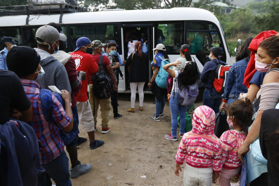 Honduran migrants trying to reach the U.S. border as a group board a public bus on the highway to Santa Barbara, early Friday, Jan. 15, 2021. The migrants left with little certainty about how far they will make it as regional governments appeared more united than ever in stopping their progress. (AP Photo/Delmer Martinez)