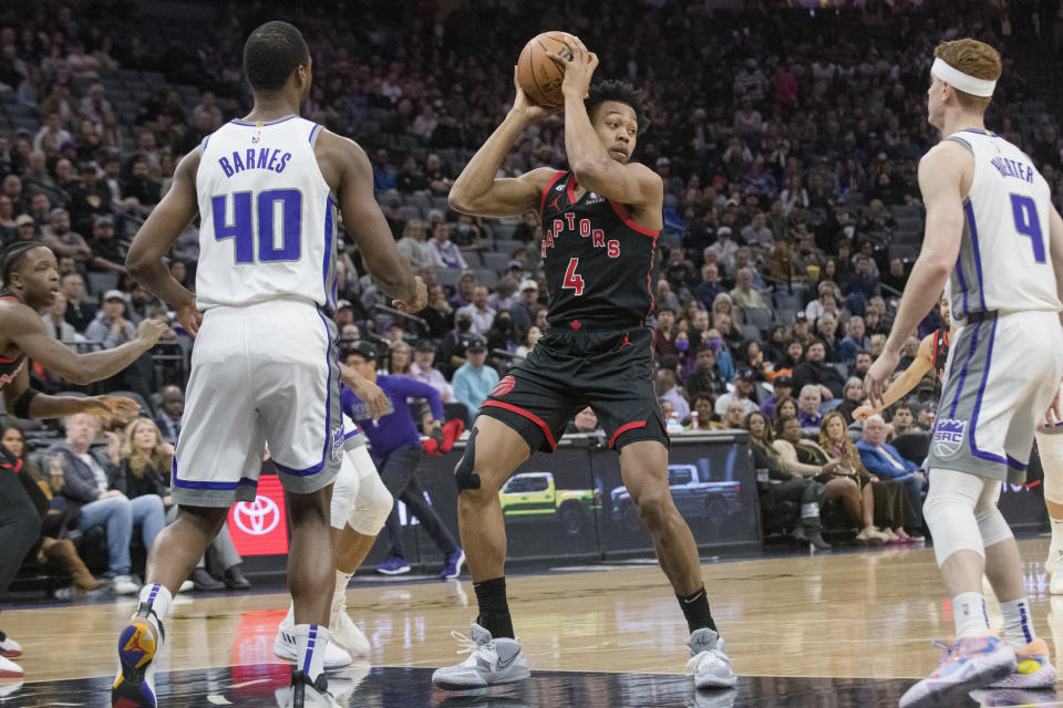 Toronto Raptors forward Scottie Barnes (4) is guarded by Sacramento Kings forward Harrison Barnes (40) and Kevin Huerter (9) during the first quarter of an NBA basketball game in Sacramento, Calif., Wednesday, Jan. 25, 2023. (AP Photo/Randall Benton)