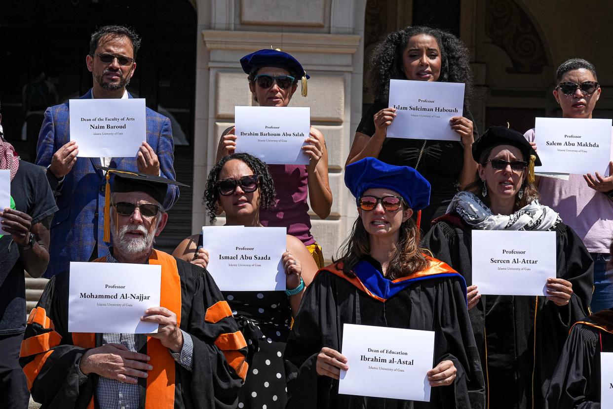 University of Texas at Austin faculty and staff hold the names of Palestinian educators during a silent vigil on the south steps of the UT Tower on Monday, April 29, 2024. The staff gathered to call for a ceasefire in Gaza and to condemn Israel for commiting a "Scholasticide," in Palestine. The term scholasticide is used in reference to the destruction of educational institutions and institutions of higher education in Palestine.