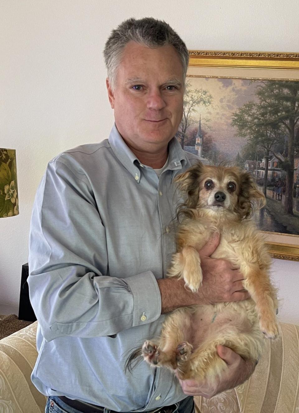 Robert Flaherty, 55, holds his deceased sister's pet dog, Holly. He and his sister Eileen Flaherty were struck by a vehicle April 2 on a sidewalk in Deltona. Eileen Flaherty perished.