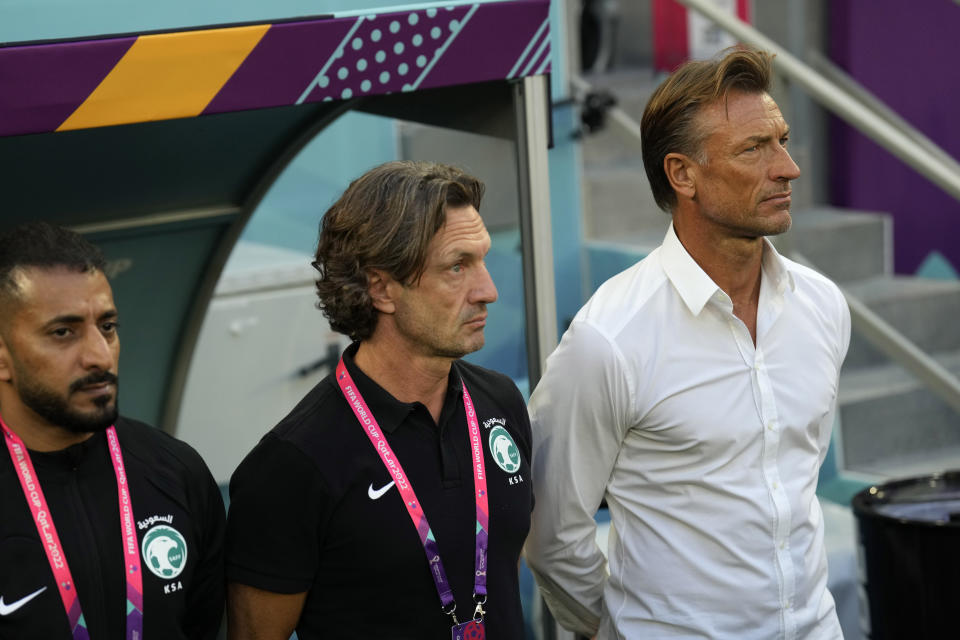 Saudi Arabia's head coach Herve Renard, right, stands for the Saudi national anthem prior to the World Cup group C soccer match between Poland and Saudi Arabia, at the Education City Stadium in Al Rayyan , Qatar, Saturday, Nov. 26, 2022. (AP Photo/Francisco Seco)