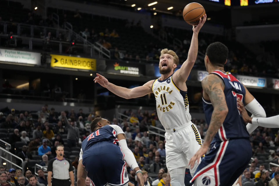 Indiana Pacers forward Domantas Sabonis (11) shoots between Washington Wizards defenders Daniel Gafford (21) and Kyle Kuzma during the second half of an NBA basketball game in Indianapolis, Monday, Dec. 6, 2021. (AP Photo/AJ Mast)