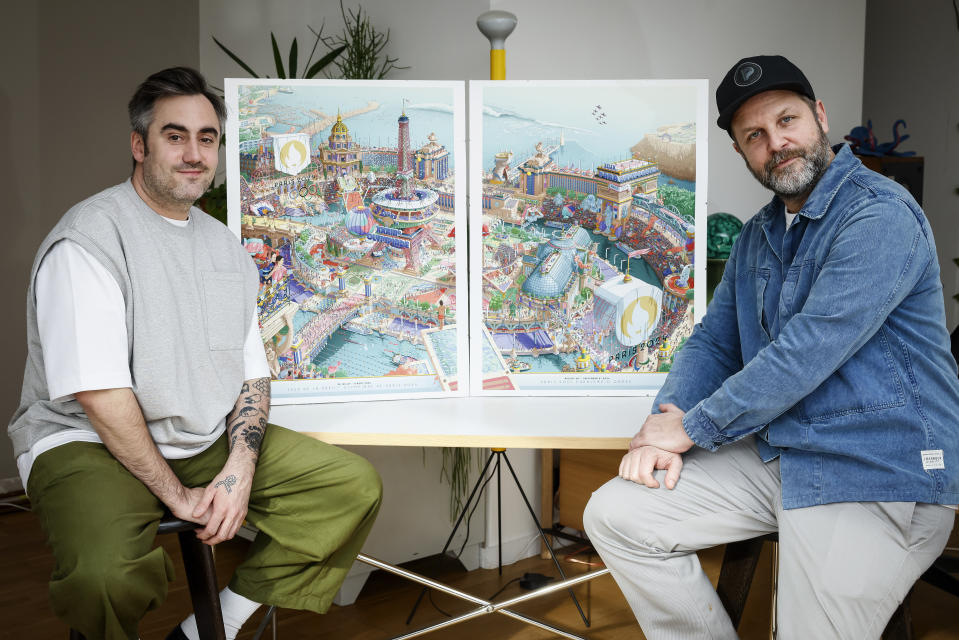 CORRECTS SPELLING OF FIRST NAME FROM HUGO TO UGO - French artist Ugo Gattoni, left, and head of design for Paris 2024, Joachim Roncin pose next to the Paris 2024 Olympic and Paralympic posters in Ivry-sur-Seine outside Paris, Tuesday Feb. 20, 2024. Vibrant colors and striking landmarks illuminate posters for the Paris Olympic Games in an Art Deco style inspired by the city's flamboyant past. The posters have been unveiled at the Musée d'Orsay. (AP Photo/Thomas Padilla)