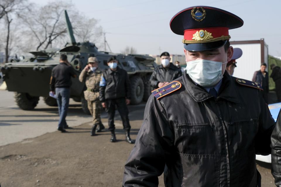 Armed Kazakhstan police wearing face masks block an area in Almaty, Kazakhstan, Thursday, March 19, 2020. A residential block in Almaty, Kazakhstan's former capital and largest city, has been surrounded by the military and blocked for entry and exit after one of the residents was diagnosed with the new coronavirus. For most people, the new coronavirus causes only mild or moderate symptoms. For some it can cause more severe illness. (AP Photo/Vladimir Tretyakov)