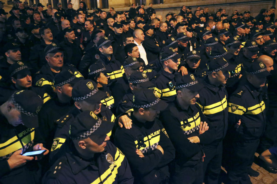 Police officers block protestors as they gather outside the parliament building in Tbilisi, Georgia, on Tuesday, April 16, 2024, to protest against "the Russian law" similar to a law that Russia uses to stigmatize independent news media and organizations seen as being at odds with the Kremlin. (AP Photo/Zurab Tsertsvadze)