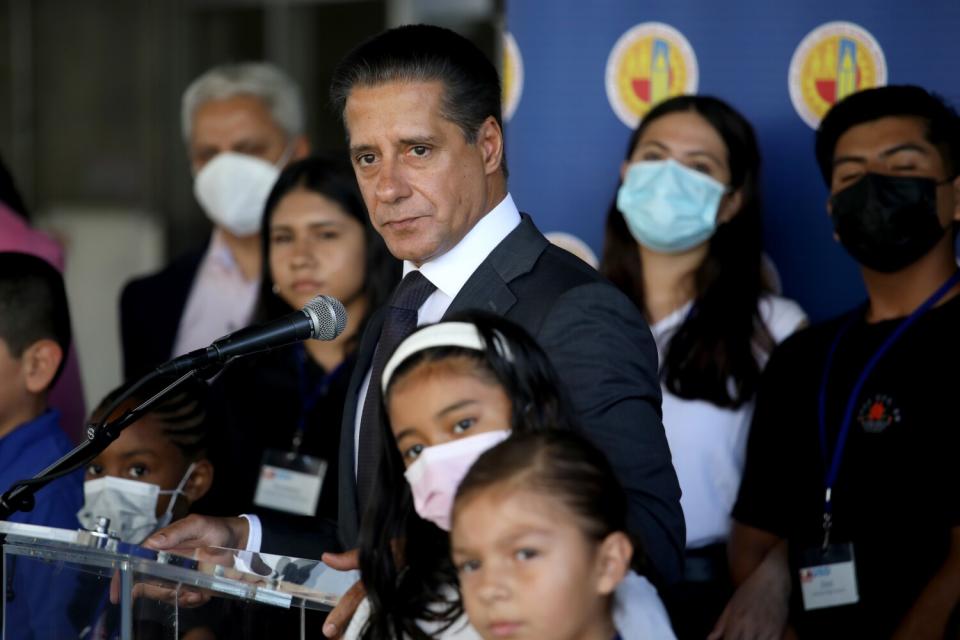 A man next to microphone with people around him.