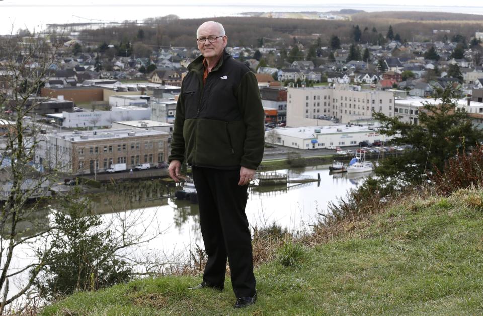 Jack Durney, mayor of Hoquiam, Wash., stands on a hill on Monday, March 18, 2014, overlooking his city, the Hoquiam River, and Grays Harbor. Because most of Hoquiam lies in the flood plain, Durney says possible increases in federal flood insurance rates would adversely affect many who live in his town. In the old logging port on an estuarine bay, the great majority of the 8,700 residents live in a flood hazard area. (AP Photo/Ted S. Warren)