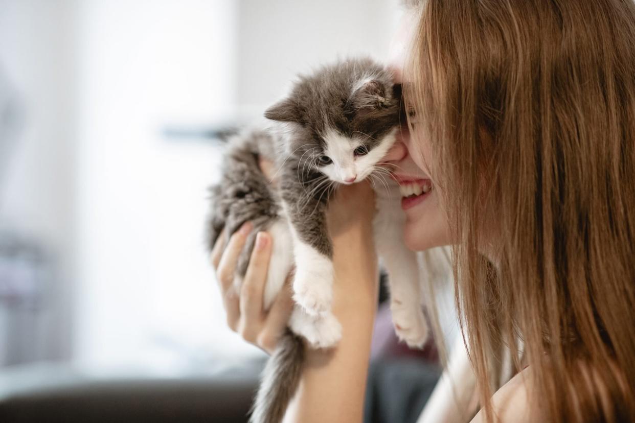 woman holding kitten to her face, First-Year Kitten Vaccination Schedule Chart