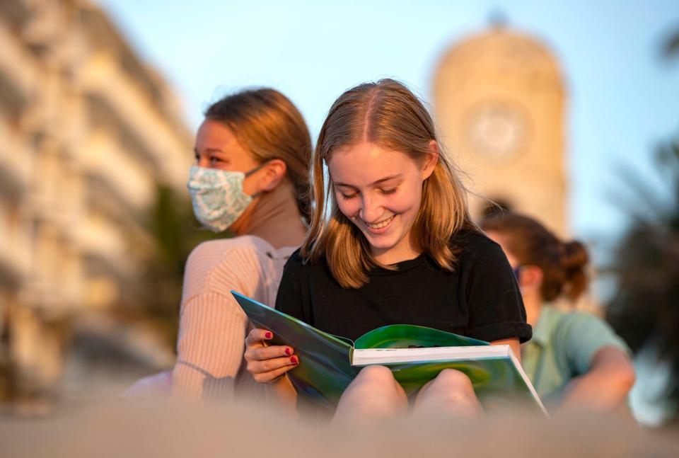 Suncoast High School seniors Barrett Rose, right, and Mia Wormus share a laugh as they sign a yearbook in Palm Beach on Aug. 10, 2020.