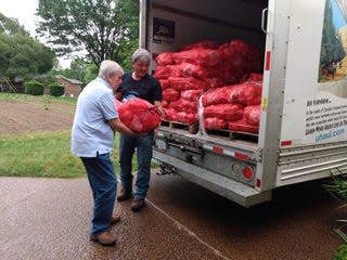 Randy Messick and Brian Calkins of the Columbia Civitan Club unpack Vidalia onions for an upcoming sale to support Jared’s Dream Playground at Maury County Park.