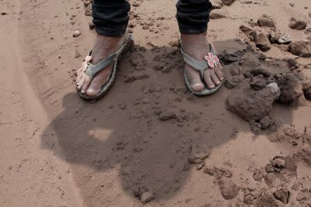 The feet of Eufemia Garcia, 48, who lost 50 members of her family during the eruption of the Fuego volcano, are seen as she searches for her family in San Miguel Los Lotes in Escuintla, Guatemala, June 14, 2018. REUTERS/Carlos Jasso