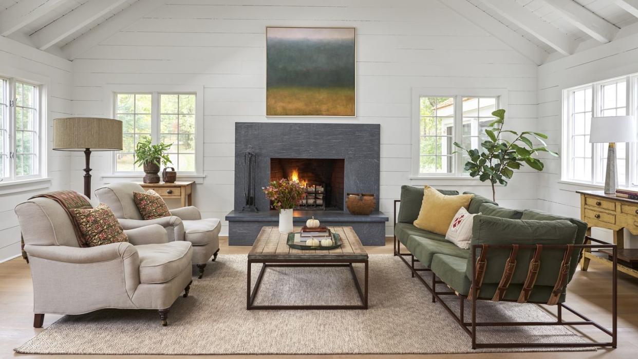 a modern farmhouse living room with a black soapstone fireplace