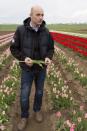 Benedikt Sellmann, co-owner of a tulip farm, stands amidst his blossoming tulips.