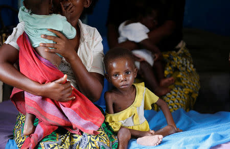 An internally displaced woman sits with her severely acute malnourished children as they wait to receive medical attention at the Tshiamala general referral hospital of Mwene Ditu in Kasai Oriental Province in the Democratic Republic of Congo, March 15, 2018. REUTERS/Thomas Mukoya/Files