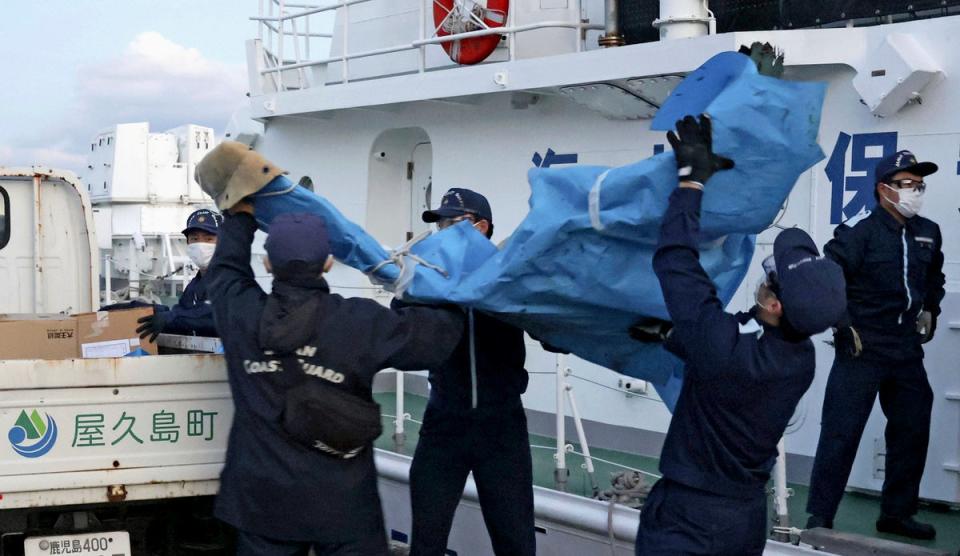 The members of Japanese Coast Guard carry the debris which are believed to be from the crashed U.S. military Osprey aircraft, at a port in Yakushima, Kagoshima prefecture, southern Japan, Monday, Dec. 4, 2023 (AP)