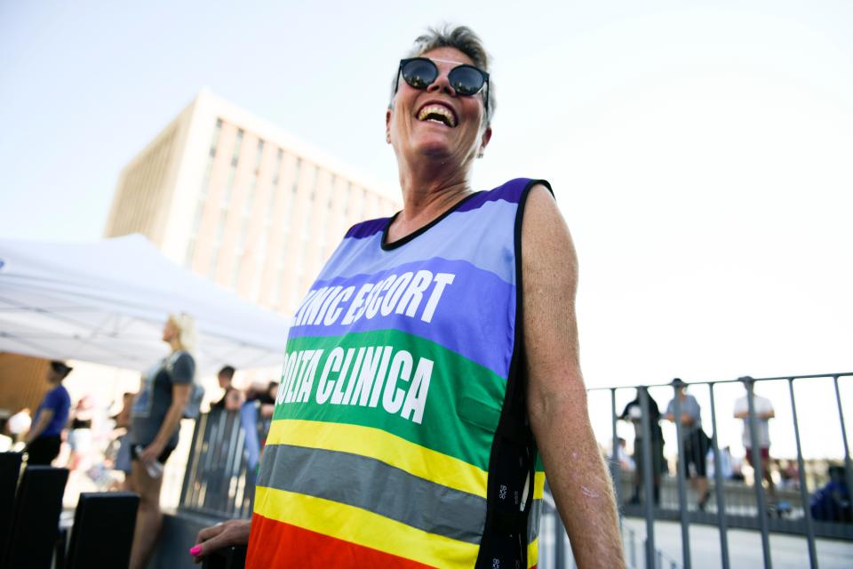 A person is seen in a rainbow vest.