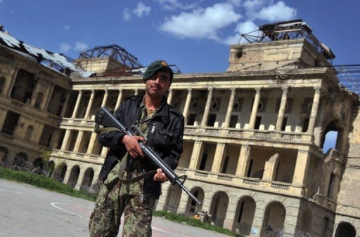 A security officer stand guard outside the Darulaman Palace in Kabul. The National Museum of Afghanistan is overlooked by living history represented by the ruins of the neoclassical Darulaman Palace on a neighbouring hill -- also a victim of war