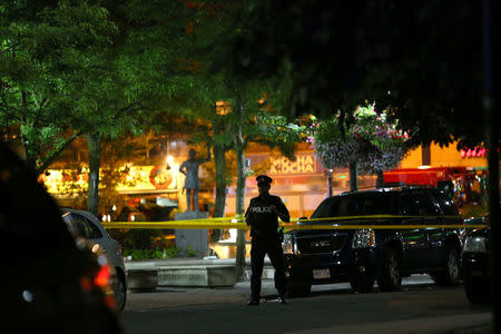 A police officer stands guard at the scene of a mass shooting in Toronto, Canada, July 22, 2018. REUTERS/Chris Helgren