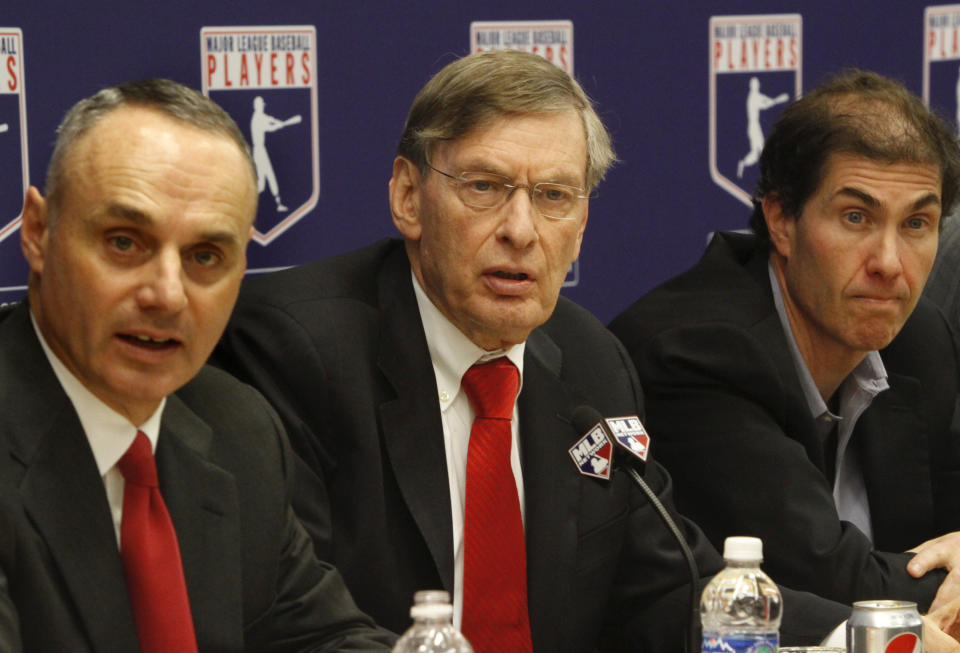 FILE - Major League Baseball commissioner Bud Selig, center, is flanked by Vice President of Labor Relations Rob Manfred, left, and MLB Players Association Executive Director Michael Weiner, during a new conference announcing a five-year collective bargaining agreement on Nov. 22, 2011 in New York. Getting a side to give back something it gained previously in collective bargaining can lead to difficult negotiations, which is why Major League Baseball has its first work stoppage in 26 years. (AP Photo/Bebeto Matthews, File)