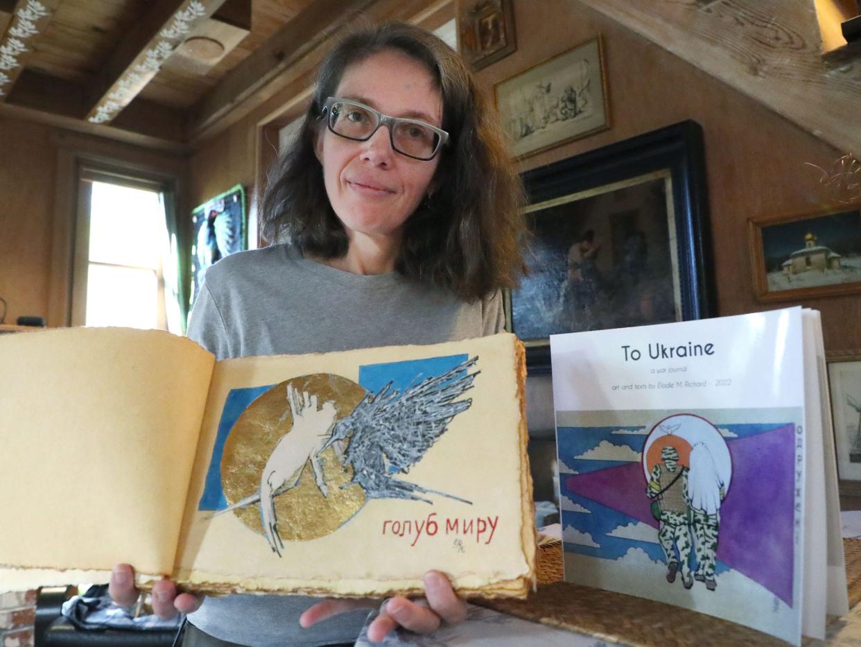 Artist Elodie Richard holds “To Ukraine – A War Journal,” her latest book of original paintings illustrating the war in Ukraine, Wednesday, Jan. 11, 2023, in her New Smyrna Beach home.