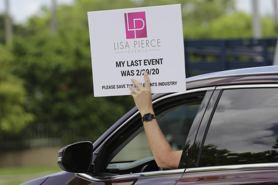 A protestor holds a sign in support of the live events industry receiving federal aid outside of the office of Sen. Marco Rubio, R-Fla., during the coronavirus pandemic, Thursday, July 30, 2020, in Miami. Many small businesses in the events industry have been shut down since March due to the pandemic. (AP Photo/Lynne Sladky)