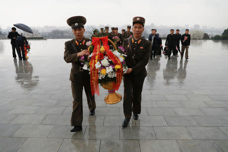 Soldiers carry flowers as they arrive to pay respects at the statues of North Korea founder Kim Il Sung and late leader Kim Jong Il in Pyongyang, North Korea April 14, 2017. REUTERS/Damir Sagolj
