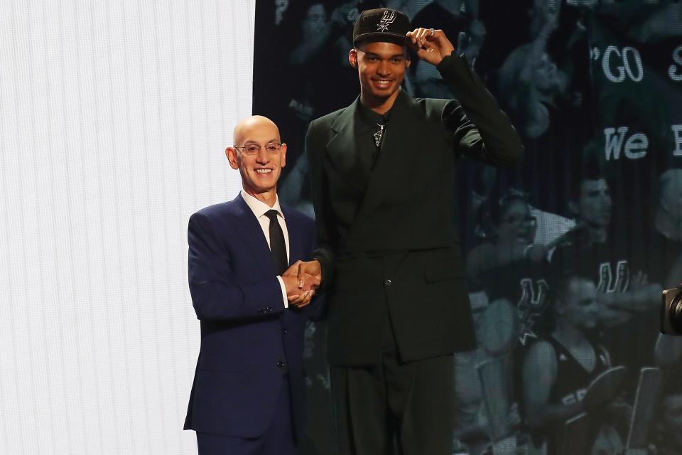 Victor Wembanyama poses for photos with NBA commissioner Adam Silver after being selected first by the San Antonio Spurs.