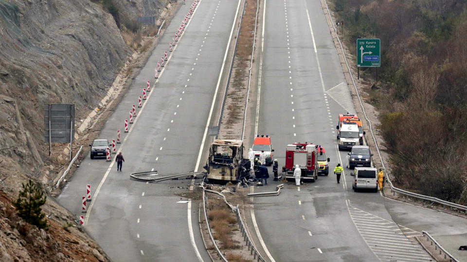 Firefighters and forensic workers inspect the scene of a bus crash which, according to authorities, killed at least 45 people on a highway near the village of Bosnek, western Bulgaria, Tuesday, Nov. 23, 2021. The bus, registered in Northern Macedonia, crashed around 2 a.m. and there were children among the victims, authorities said. (AP Photo/Valentina Petrova)