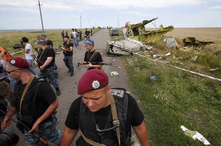 Armed pro-Russian separatists stand guard at a crash site of Malaysia Airlines Flight MH17, near the village of Hrabove, Donetsk region July 20, 2014. REUTERS/Maxim Zmeyev