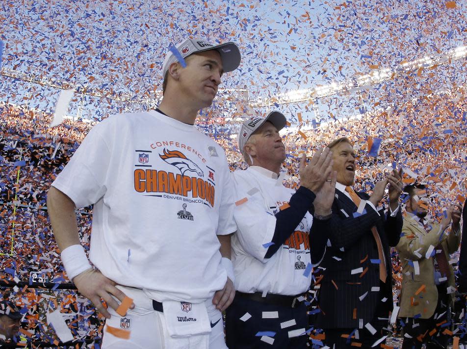 Denver Broncos quarterback Peyton Manning, stands with Broncos' head coach John Fox and Broncos VP John Elway during the trophy ceremony after the AFC Championship NFL playoff football game in Denver, Sunday, Jan. 19, 2014. The Broncos defeated the Patriots 26-16 to advance to the Super Bowl. (AP Photo/Charlie Riedel)